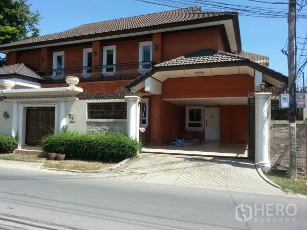 บ้าน ให้เช่าในWatthana, Bangkok - ด้านหน้าบ้านติดถนน หลังคากระเบื้อง มีประตูรั้วและที่จอดรถในร่ม