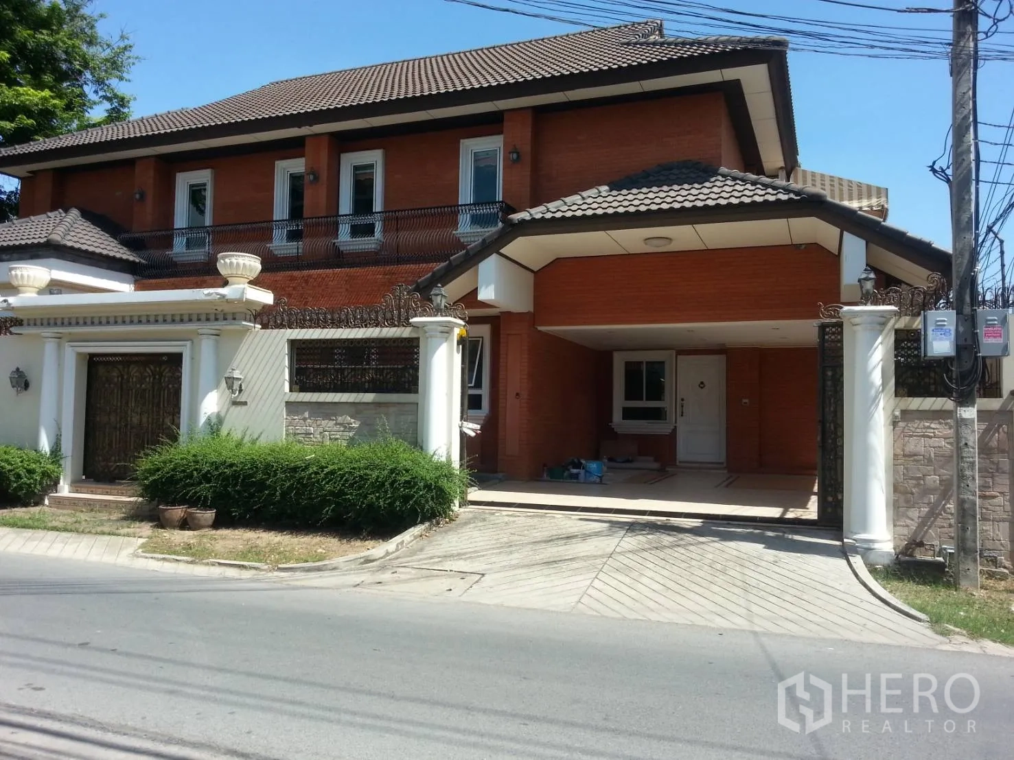 บ้าน ให้เช่าในWatthana, Bangkok - ด้านหน้าบ้านติดถนน หลังคากระเบื้อง มีประตูรั้วและที่จอดรถในร่ม