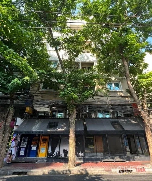 零售空间 出租在Bang Rak, Bangkok - 临街立面被茂密行道树遮蔽的商住楼。