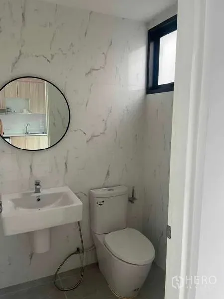 ทาวน์เฮาส์ ให้เช่าในSuan Luang, Bangkok - ห้องน้ำกะทัดรัด ผนังลายหินอ่อน กระจกทรงกลม อ่างล้างหน้าแบบเหลี่ยม โถสุขภัณฑ์ และหน้าต่างบานเล็ก