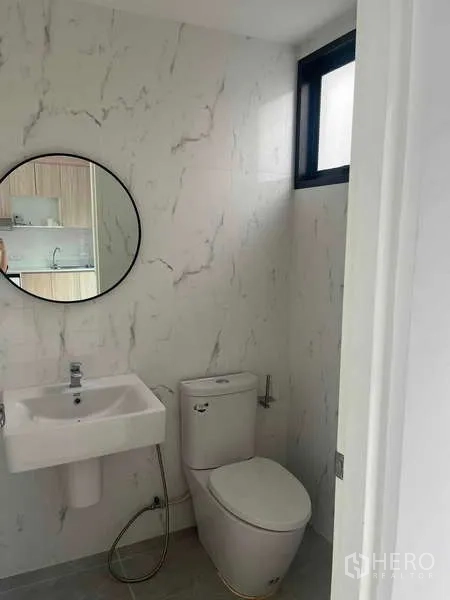 ทาวน์เฮาส์ ให้เช่าในSuan Luang, Bangkok - ห้องน้ำกะทัดรัด ผนังลายหินอ่อน กระจกทรงกลม อ่างล้างหน้าแบบเหลี่ยม โถสุขภัณฑ์ และหน้าต่างบานเล็ก