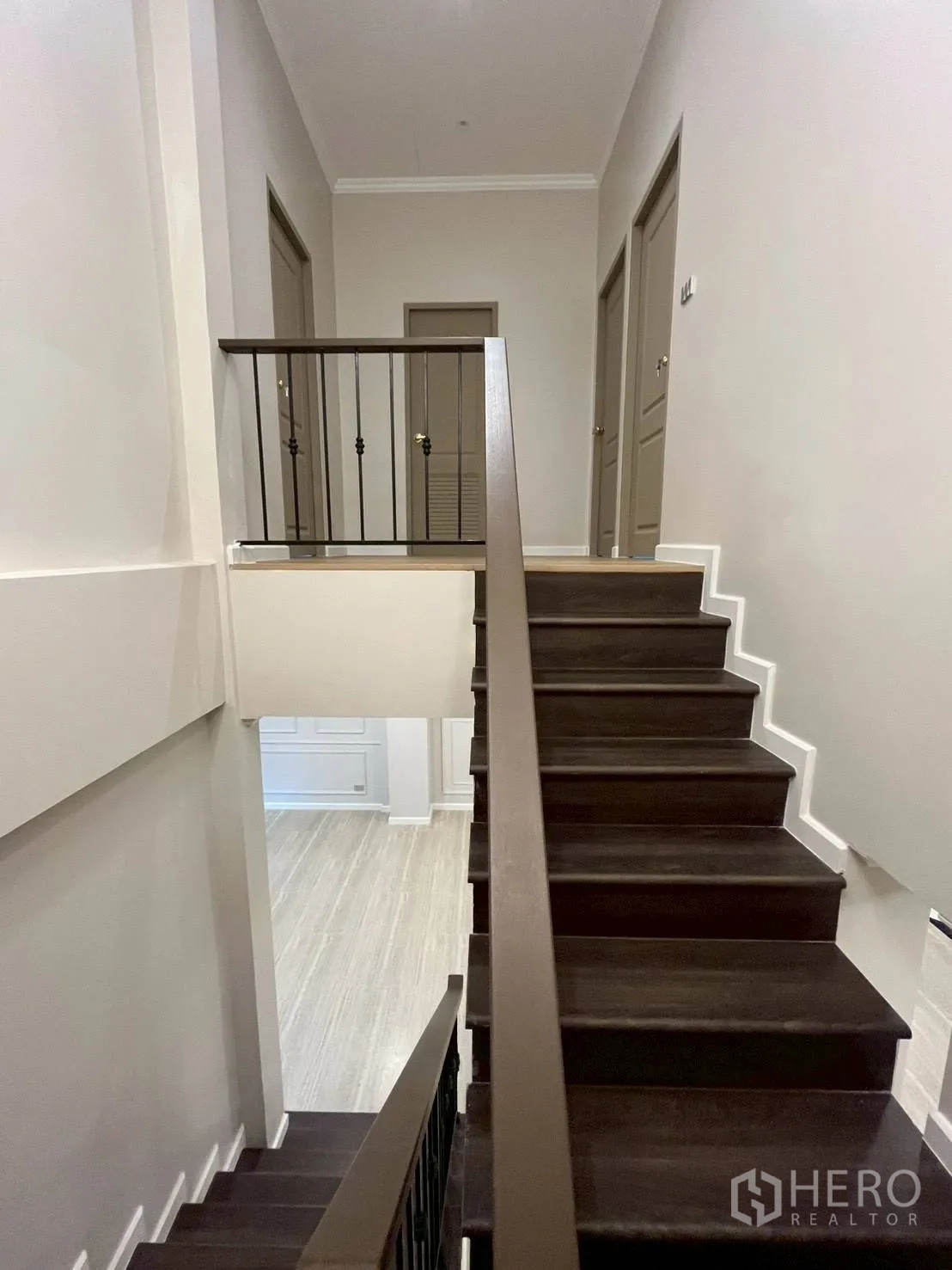 ทาวน์เฮาส์ for rent in Khlong Toei, Bangkok - บันไดภายในบ้านไม้สีเข้มพร้อมราวเหล็ก.