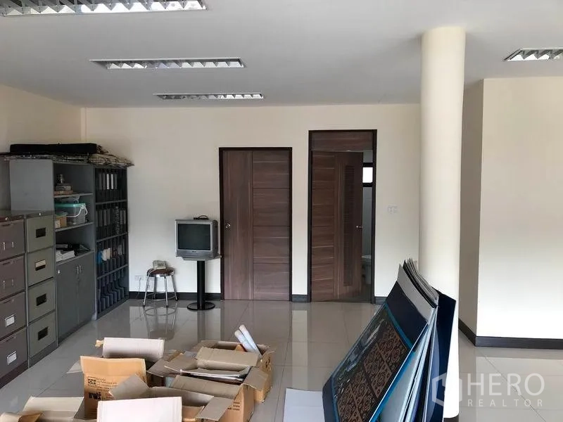 Home Office for rent in Khlong Toei, Bangkok - Open-plan workspace with filing shelves, storage cabinets and two wooden doors.