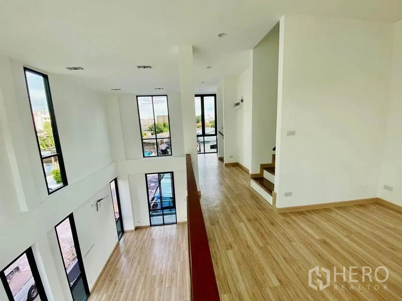 Home Office for sale in Wang Thonglang, Bangkok - Mezzanine level overlooking a double-height gallery with tall windows and stairs.