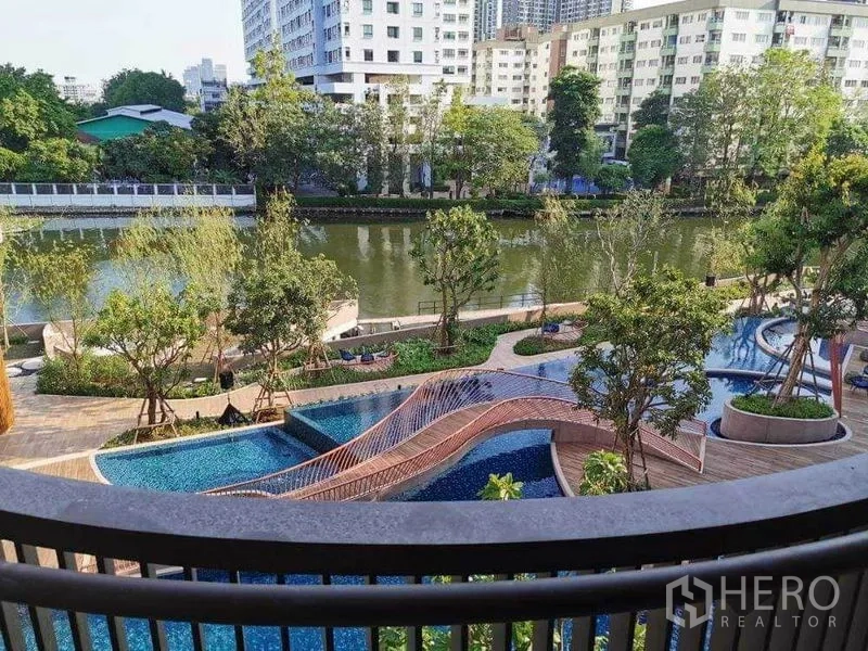 公寓 出租在Watthana, Bangkok - 泻湖式泳池与弧形步桥，临河与花园景观。