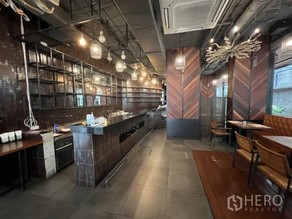 พื้นที่ขายปลีก ให้เช่าในWatthana, Bangkok - เคาน์เตอร์บาร์ยาว ชั้นวางเปิด เพดานสไตล์อินดัสเทรียล โคมไฟกรง และเบาะนั่งบูธ