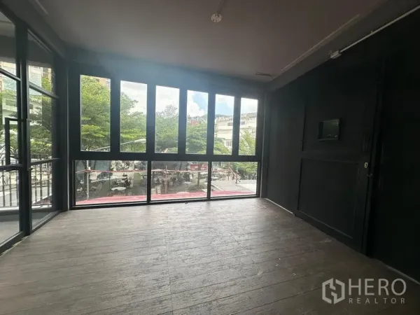 พื้นที่ขายปลีก ให้เช่า - ห้องมุมกระจกสูงจากพื้นจรดเพดาน มองออกสู่ลานต้นไม้ ใกล้ BTS พระโขนง