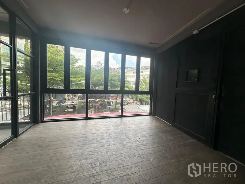 พื้นที่ขายปลีก ให้เช่า - ห้องมุมกระจกสูงจากพื้นจรดเพดาน มองออกสู่ลานต้นไม้ ใกล้ BTS พระโขนง