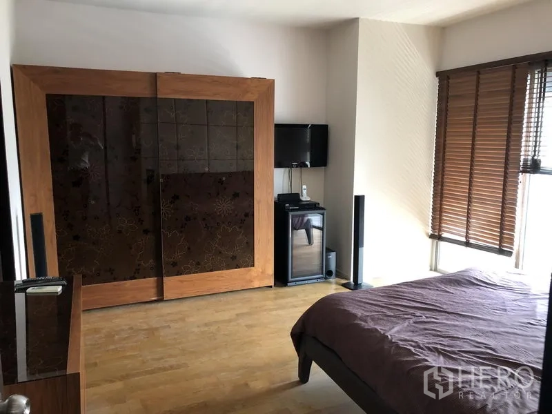 คอนโด ให้เช่าในWatthana, Bangkok - ห้องนอนหลักมีตู้เสื้อผ้าบานเลื่อนไม้ขนาดใหญ่ ทีวี และหน้าต่างพร้อมมู่ลี่