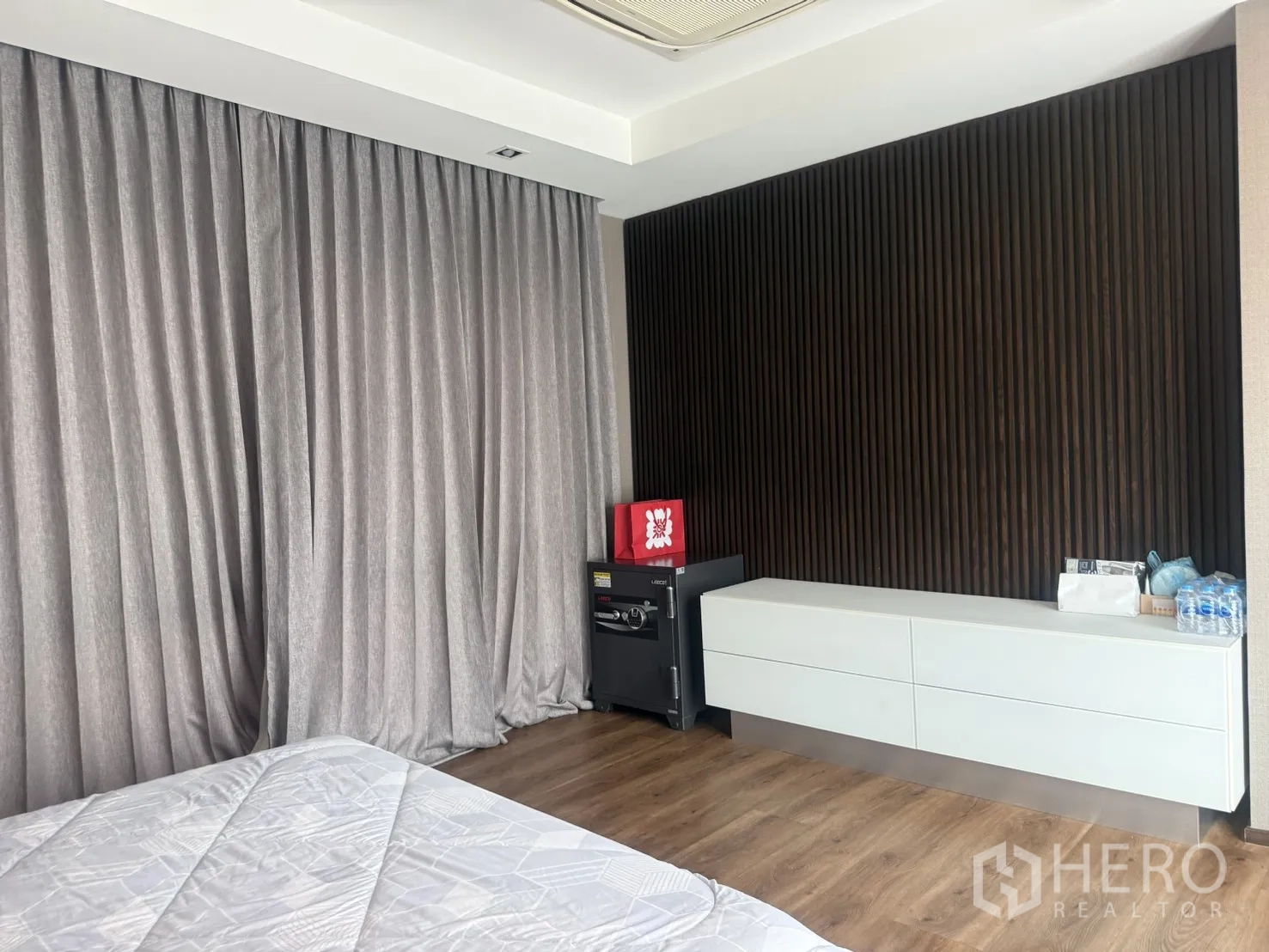 บ้านเดี่ยว for rent in Bang Kapi, Bangkok - มุมห้องนอน ผนังตกแต่งระแนงสีเข้ม ตู้ล่างยาว และตู้เซฟ