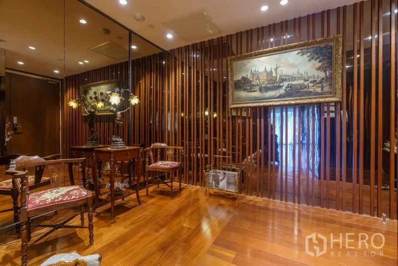 Condominium for sale in Yan Nawa, Bangkok - Cozy seating nook with antique chairs, mirrored wall and framed painting.