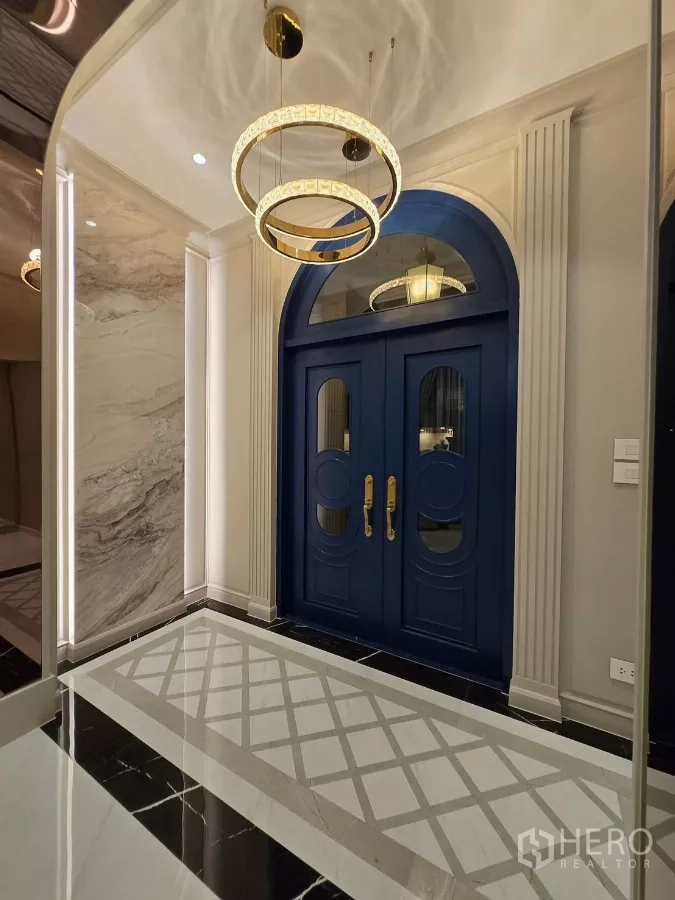 Detached House for rent or sale in Bang Kapi, Bangkok - Close-up of blue arched front doors with brass handles under circular chandeliers.