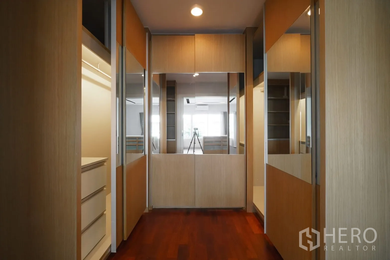 Detached House for rent or sale in Saphan Sung, Bangkok - Walk-in closet corridor with mirrored doors and cabinetry.