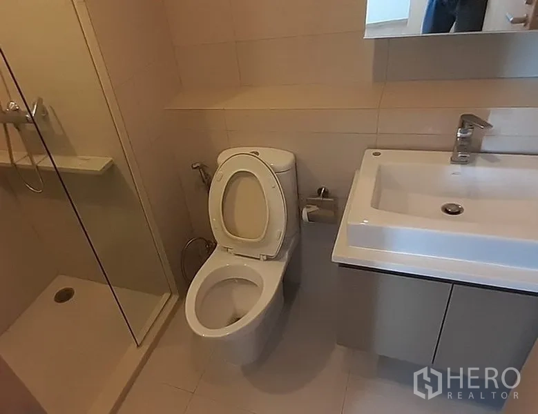 คอนโด ให้เช่าในKhlong Toei, Bangkok - ห้องน้ำสไตล์ร่วมสมัย พร้อมอ่างล้างหน้า โถสุขภัณฑ์ และโซนอาบน้ำกระจก โทนสีอบอุ่น