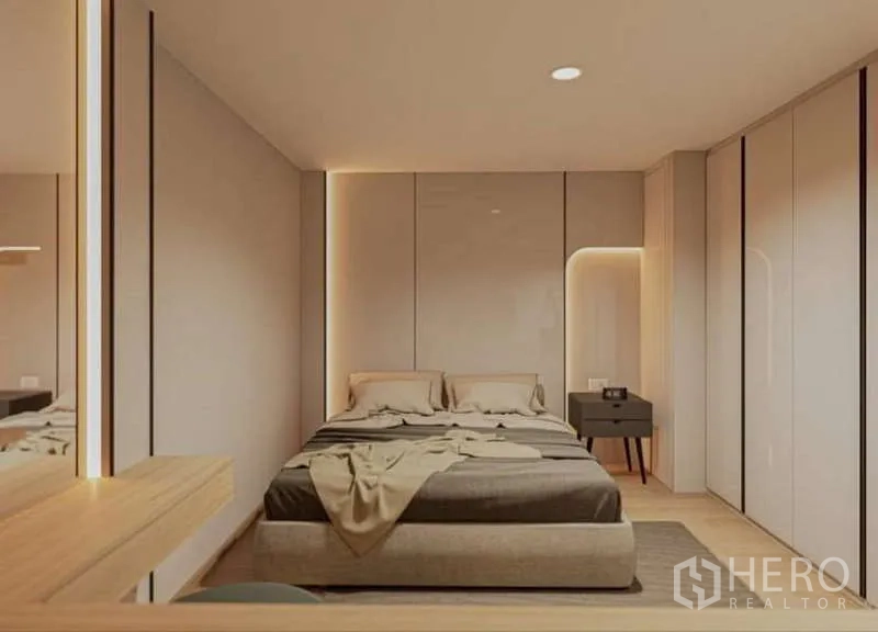 Condominium for rent in Huai Khwang, Bangkok - Symmetrical bedroom with soft wall panels and lit niche beside the bed.