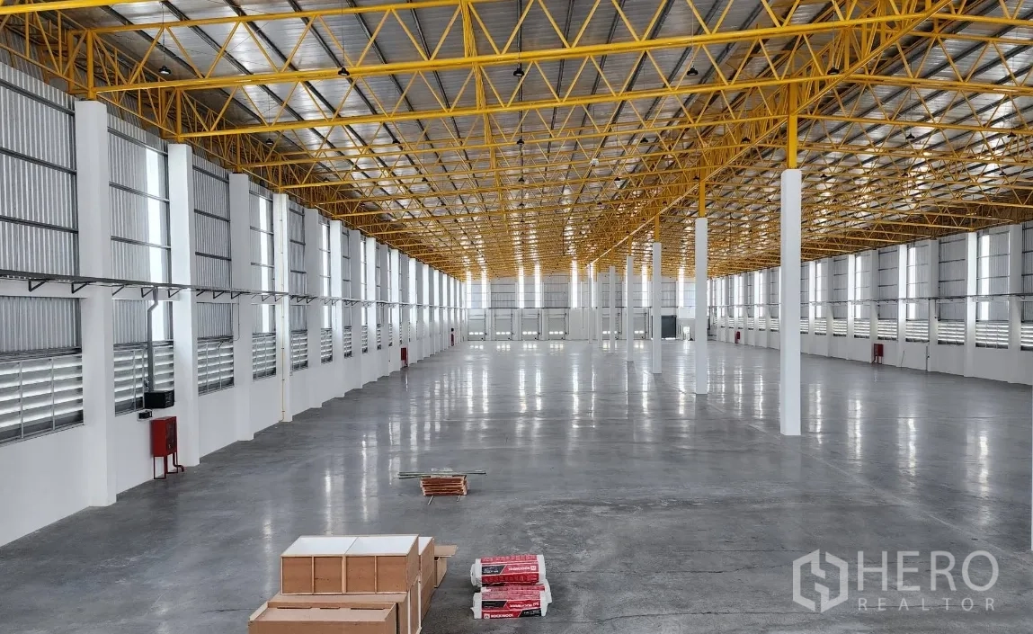 Warehouse for rent in Lat Krabang, Bangkok - Wide-span warehouse interior with polished concrete floor, tall truss roof, columns, and ventilation louvers.