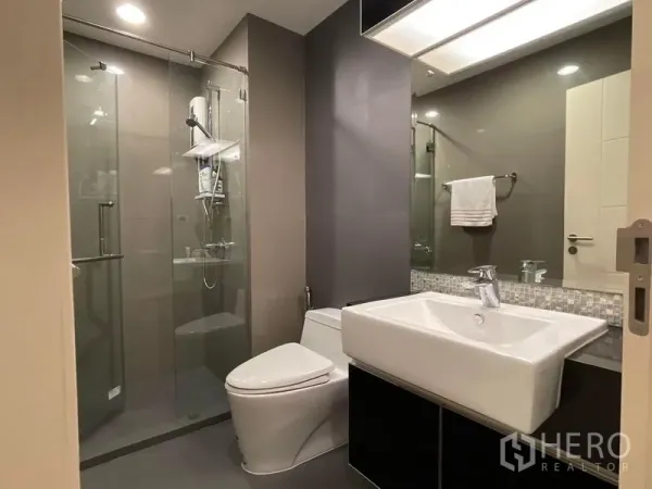 คอนโด ขายในKhlong Toei, Bangkok - ห้องน้ำโมเดิร์นพร้อมตู้กระจกอาบน้ำ อ่างล้างหน้า และโถสุขภัณฑ์