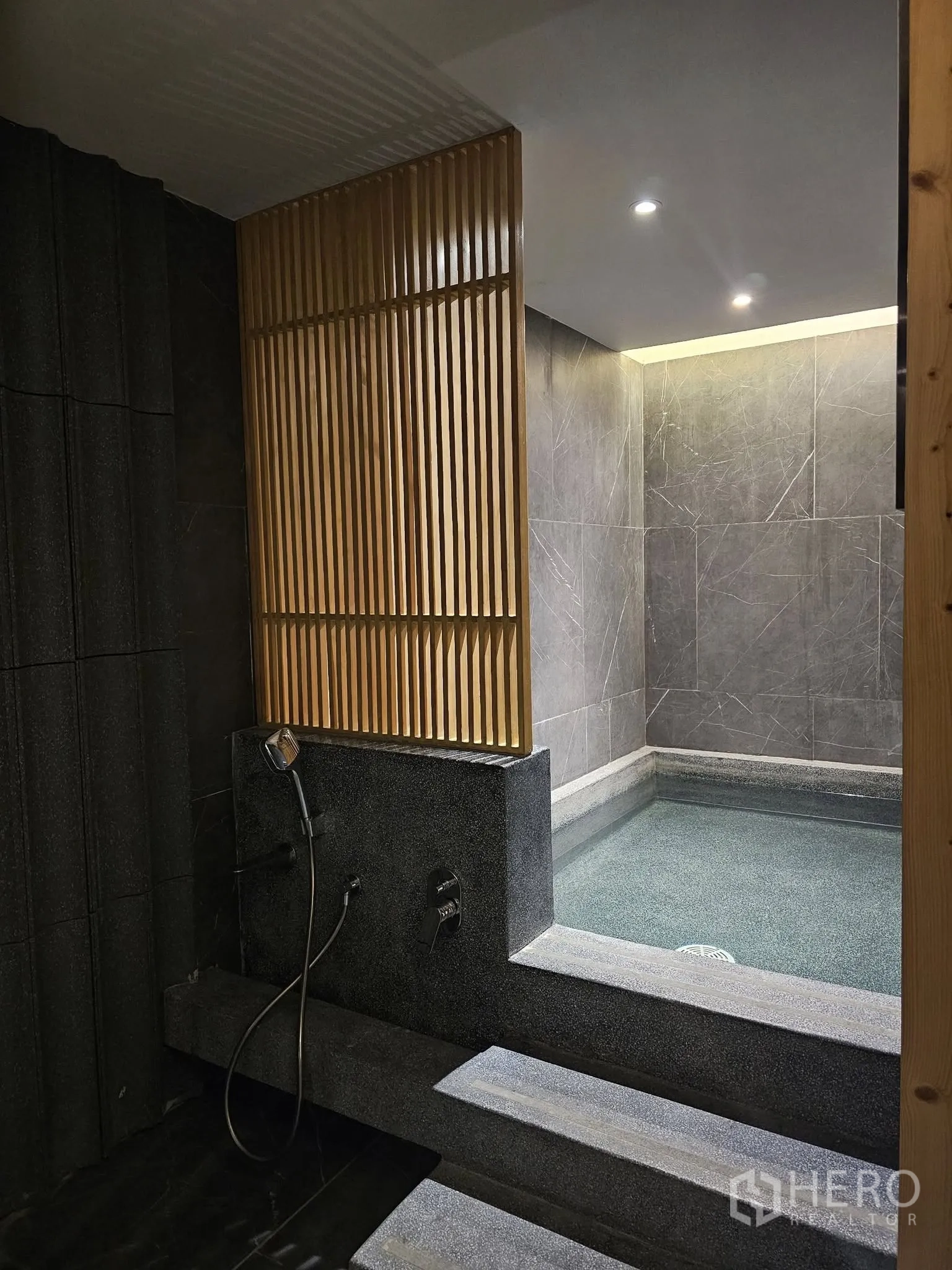 公寓 出租在Watthana, Bangkok - 日式温泉与淋浴区，石材质感与木格栅。