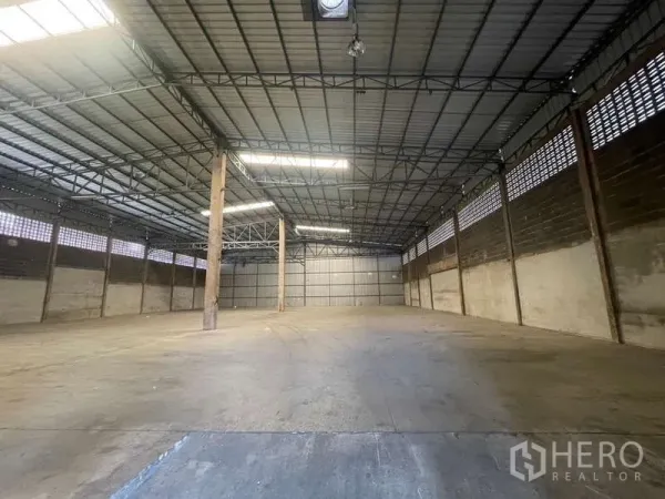 Warehouse for rent in Rat Burana, Bangkok - Spacious warehouse interior with high steel truss roof, skylights and durable concrete floor ideal for pallet storage.