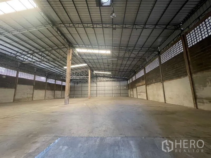 Warehouse for rent in Rat Burana, Bangkok - Spacious warehouse interior with high steel truss roof, skylights and durable concrete floor ideal for pallet storage.