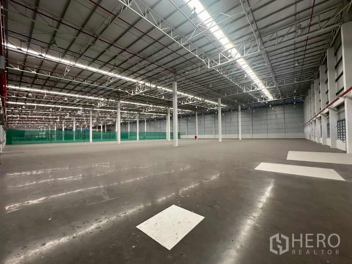 Warehouse for rent in Bang Phli, Samut Prakan - Spacious clear-span warehouse interior with high steel truss roof and polished floor.