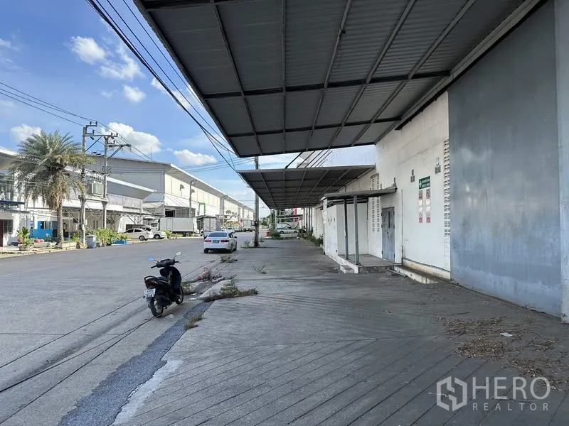 工厂 出租在Bang Bua Thong, Nonthaburi - 带雨棚的人行与装卸区，临静谧工业街道。