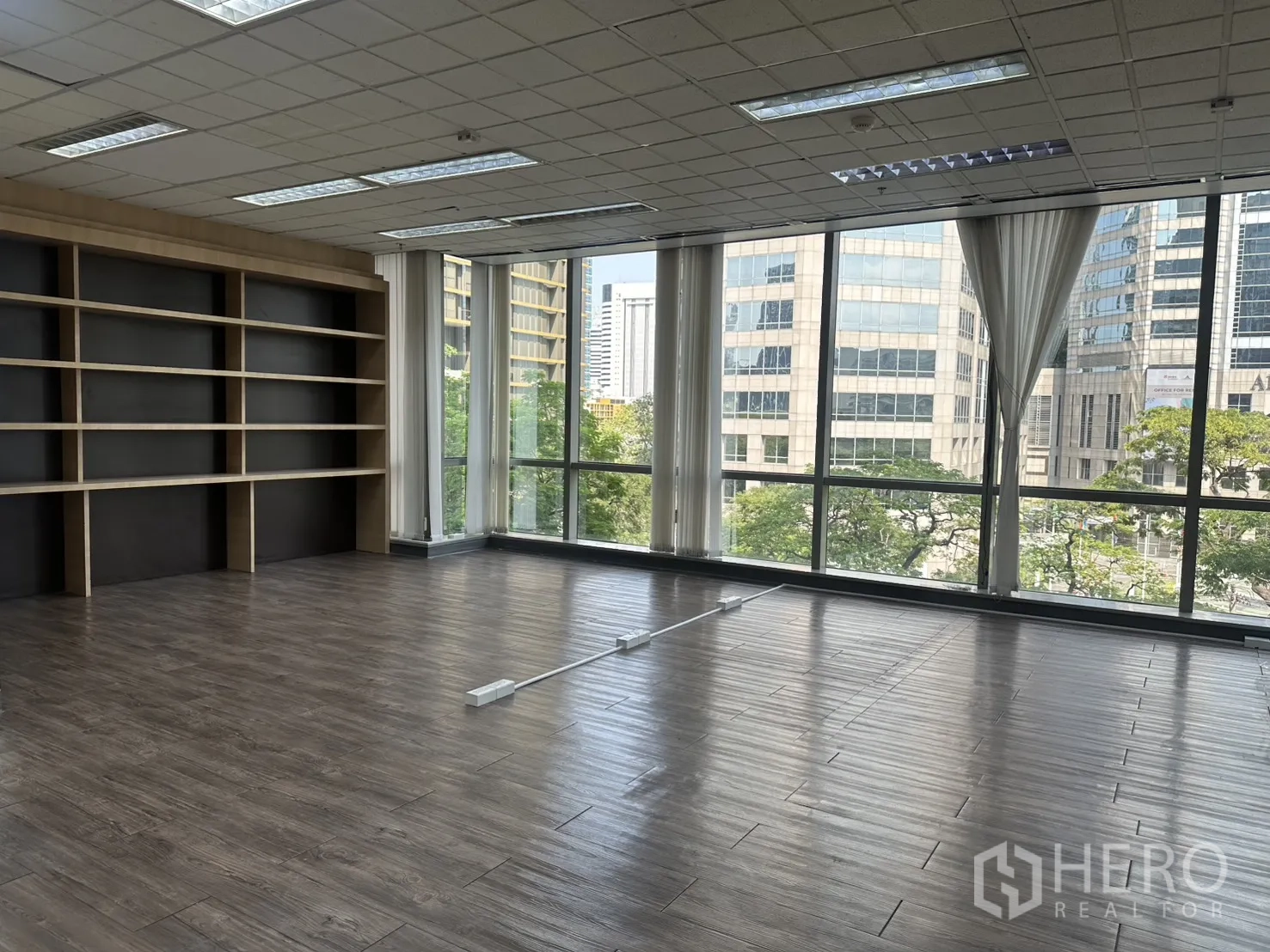 ออฟฟิศ for rent in Pathum Wan, Bangkok - พื้นที่มุมห้องกระจกสูงจากพื้นจรดเพดานพร้อมชั้นวางบิลท์อินและวิวเมือง
