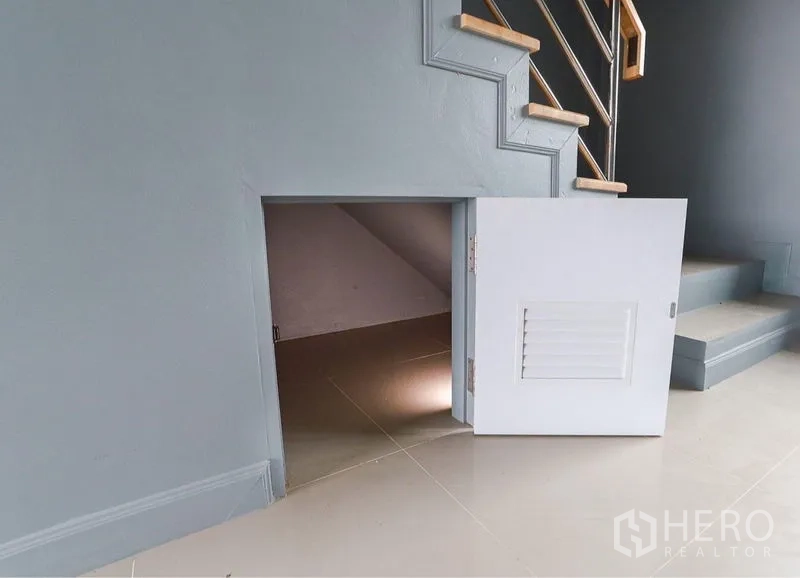 Shophouse for sale in Lam Luk Ka, Pathum Thani - Under-stair storage with a ventilated door inside a Lam Luk Ka shophouse.