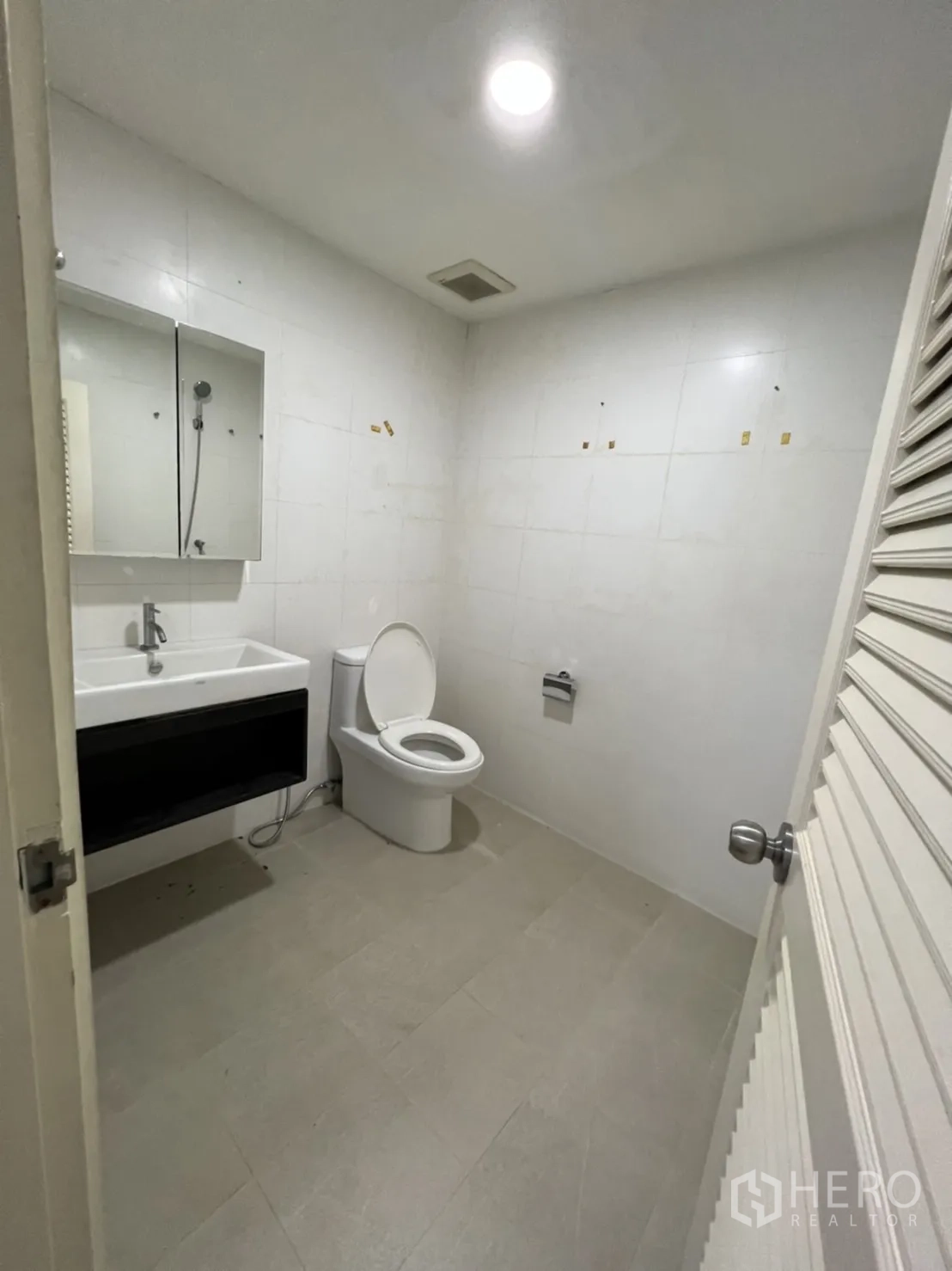 店屋 出租或出售在Watthana, Bangkok - 简洁卫生间，坐便器、洗手盆与镜子