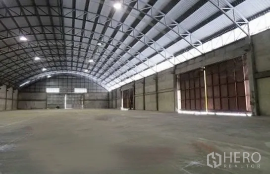 Warehouse for rent in Phra Pradaeng, Samut Prakan - Bright warehouse interior showing steel beams, skylights and several side loading bays.