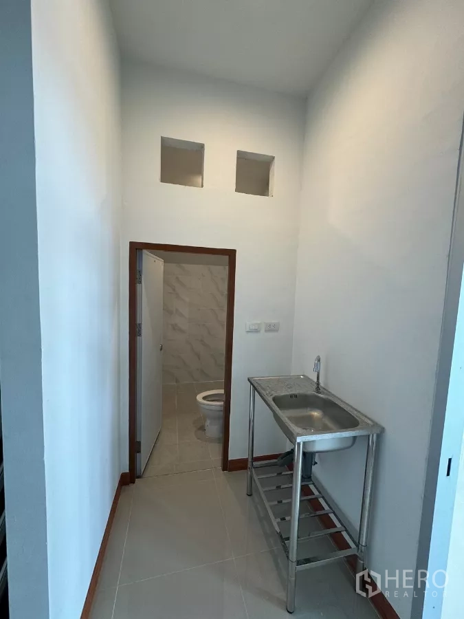 Warehouse for rent in Bang Khun Thian, Bangkok - Pantry area with stainless sink and access to a restroom.