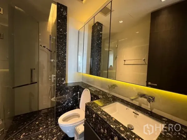 คอนโด ให้เช่า - ห้องน้ำหินอ่อนพร้อมตู้กระจก ฝักบัวกระจกกั้น และไฟใต้เคาน์เตอร์