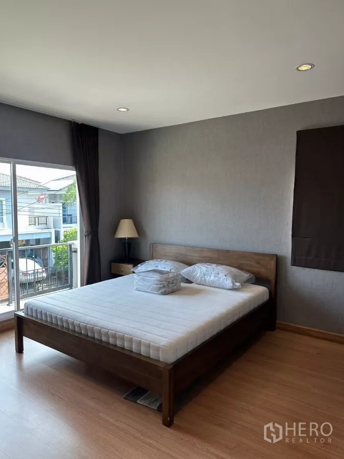 บ้าน ให้เช่าในSuan Luang, Bangkok - ห้องนอนใหญ่ หน้าต่างบานกว้าง เชื่อมระเบียงและเตียงไม้.