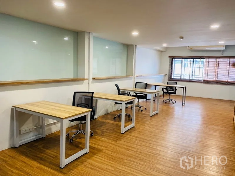 办公空间 出租在Bang Rak, Bangkok - 宽敞开放工位区，多个书桌、百叶窗与木地板