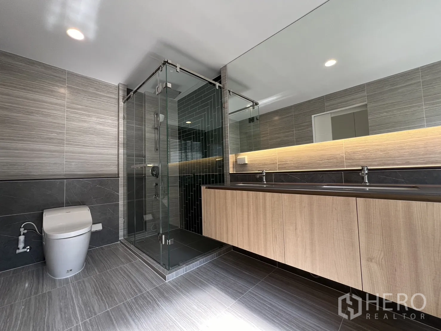 Detached House for rent or sale in Bang Kapi, Bangkok - Upstairs family room with illuminated built-in shelving and sectional sofa.