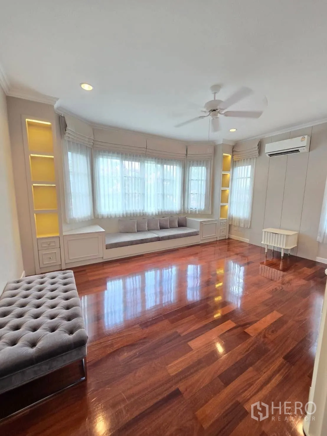 Detached House for rent in Bang Na, Bangkok - Spacious room with bay window, built-in seating, and ceiling fan.