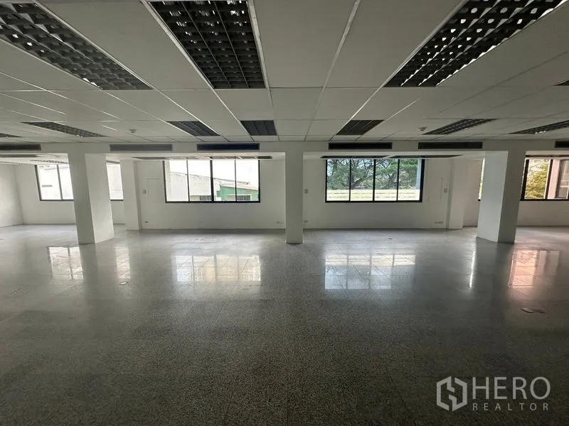 สำนักงาน ให้เช่า - พื้นที่สำนักงานเปิดโล่ง มองเห็นวิวพื้นที่สีเขียว มีเสาโครงสร้างและพื้นหินขัด