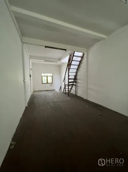 อาคารพาณิชย์ ให้เช่าในKhlong Toei, Bangkok - ชั้นบนห้องยาว พื้นไม้สีเข้ม ผนังสีขาว มีหน้าต่างบานเล็ก และบันไดเหล็กภายใน