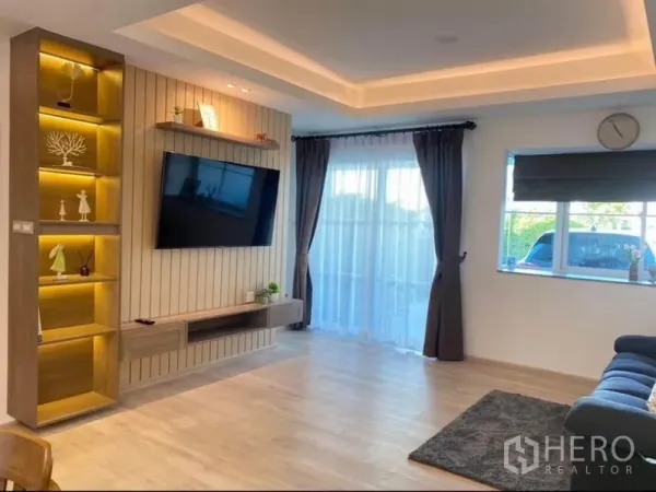 联排别墅 出租在Prawet, Bangkok - 客厅，壁挂电视与发光陈列架，落地阳台门。