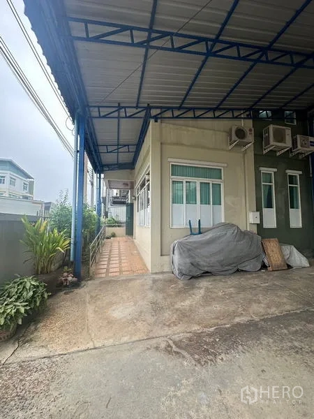 คลังสินค้า ให้เช่าหรือขายในLam Luk Ka, Pathum Thani - ด้านข้างอาคารใต้กันสาด เห็นคอมเพรสเซอร์แอร์หลายตัวและทางลาด