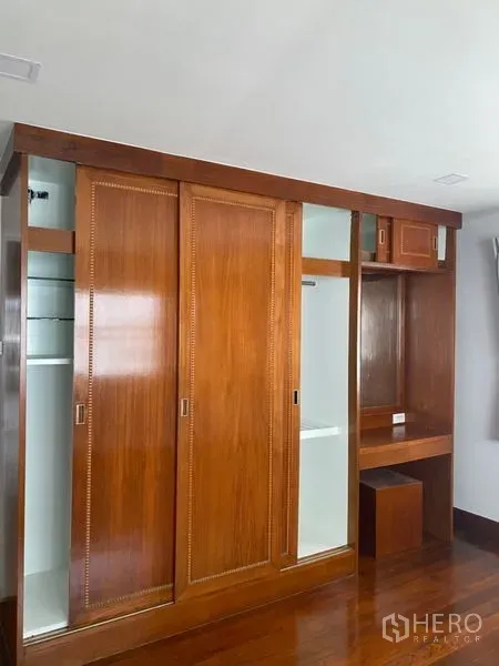 公寓 出租在Sathon, Bangkok - 木质推拉衣柜特写，带梳妆位与多功能储物格。