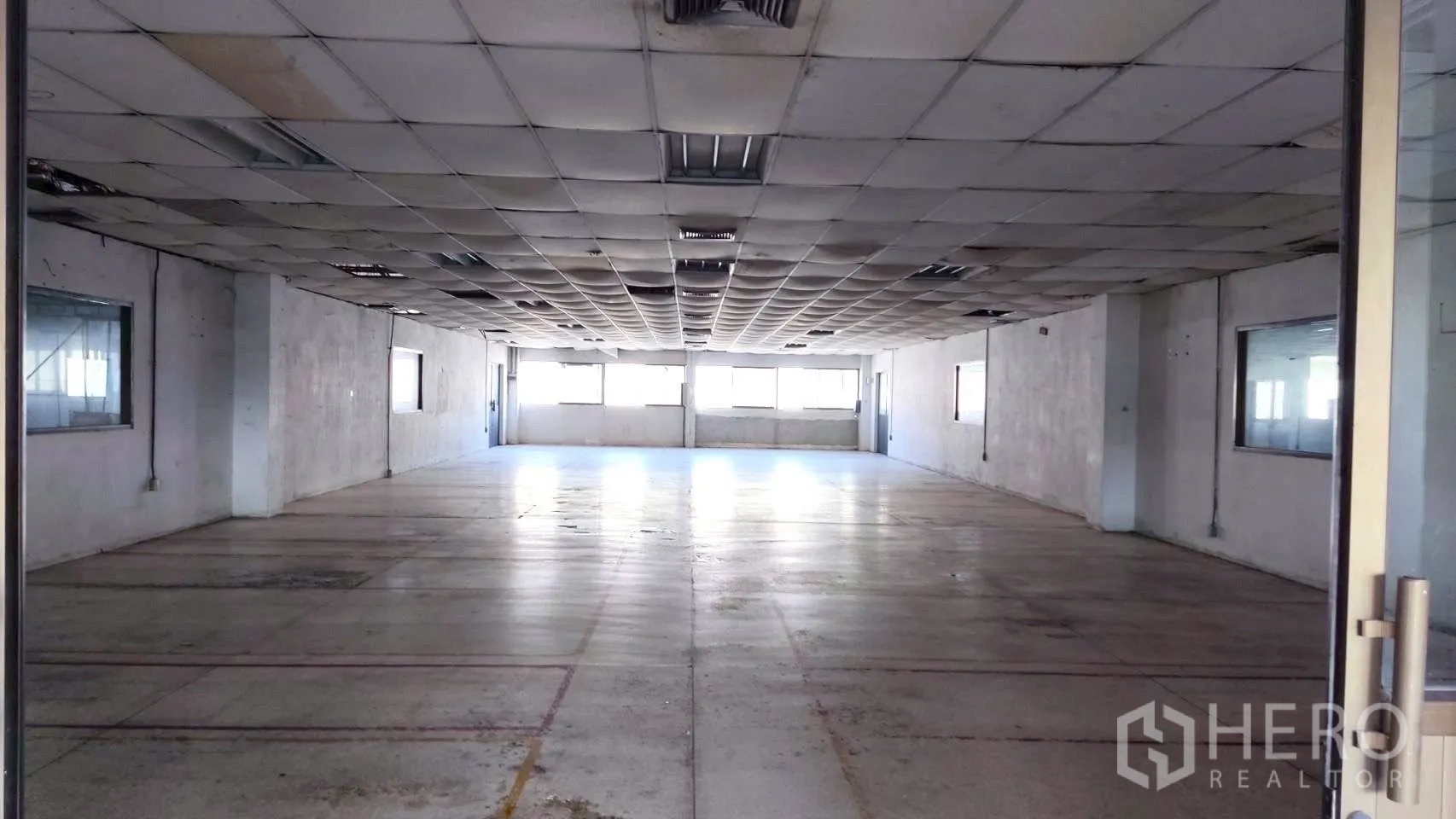 工厂 for sale in Lat Krabang, Bangkok - 宽敞大厅，吊顶格栅与长条灯，尽头设窗。