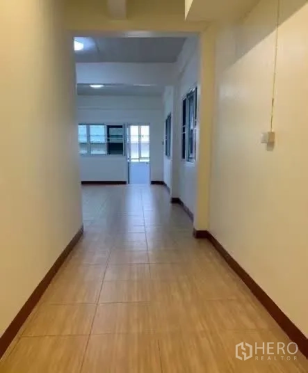 Home Office for rent in Sathon, Bangkok - Long corridor with tile floor leading to a bright room.