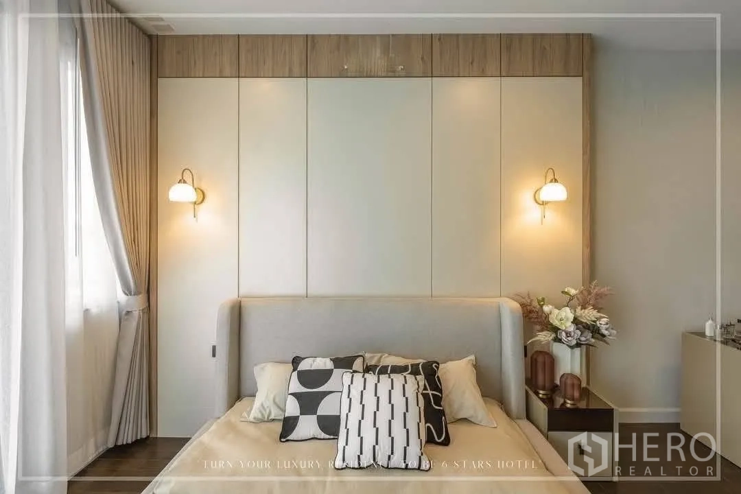 Detached House for rent or sale in Suan Luang, Bangkok - Cozy bedroom with wall sconces, bed and decorative side table.