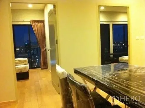 คอนโด ให้เช่าในWatthana, Bangkok - พื้นที่ทานอาหารพร้อมโต๊ะหินอ่อน เชื่อมทางไปห้องนอนสองห้อง มองเห็นวิวเมืองยามค่ำผ่านหน้าต่างบานใหญ่