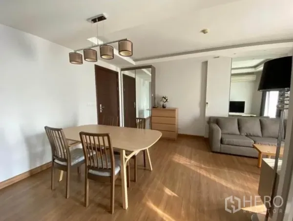 คอนโด ให้เช่าในHuai Khwang, Bangkok - โต๊ะทานอาหารข้างโซฟา ในห้องนั่งเล่นคอนโดสว่างพื้นไม้