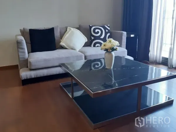 คอนโด ให้เช่าในWatthana, Bangkok - มุมพักผ่อนโซฟาสีเทา โต๊ะกลางหินลาย และผ้าม่านโปร่ง