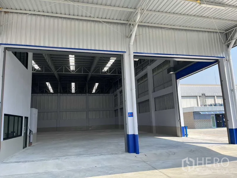 Warehouse for rent in Khlong Luang, Pathum Thani - Twin extra-wide entry bays under a covered loading canopy at the warehouse.
