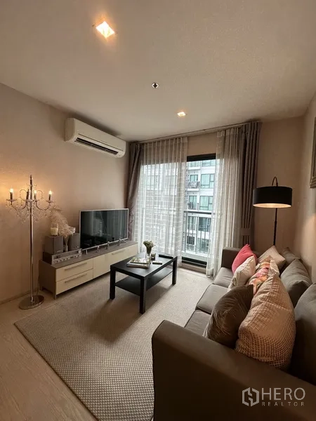 คอนโด ให้เช่าหรือขายในKhlong Toei, Bangkok - พื้นที่นั่งเล่นพร้อมทีวี เครื่องปรับอากาศ โต๊ะกลาง และประตูกระจกสู่ระเบียง