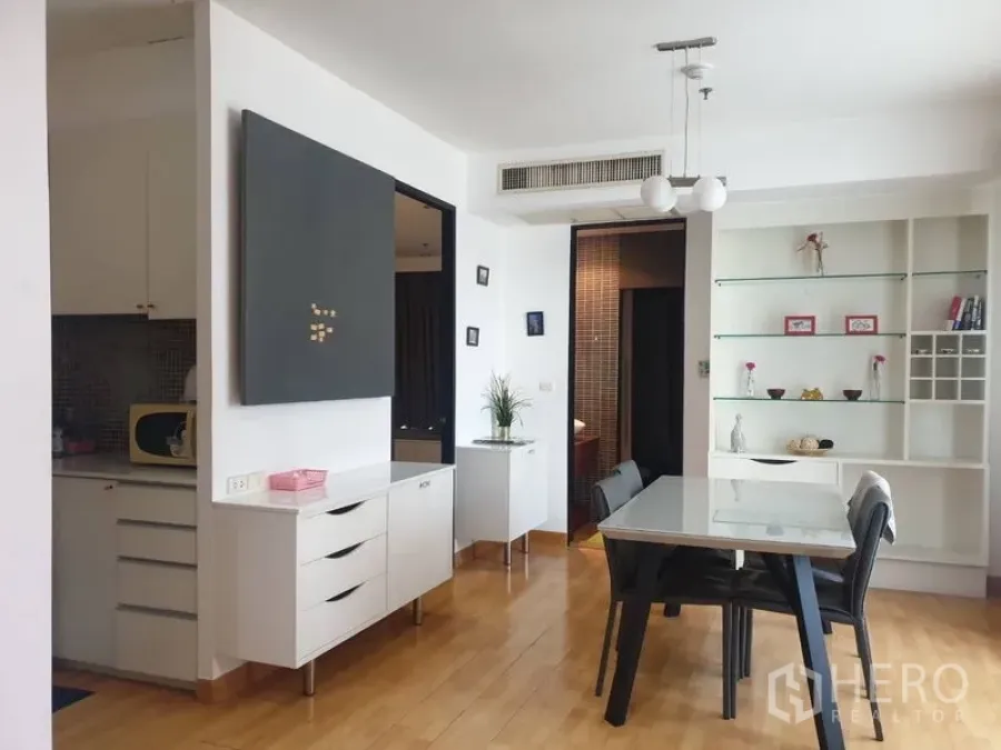 คอนโด ให้เช่าในKhlong Toei, Bangkok - มุมรับประทานอาหารสว่าง มีชั้นบิลท์อิน โคมไฟแขวน และพื้นไม้ ข้างครัว